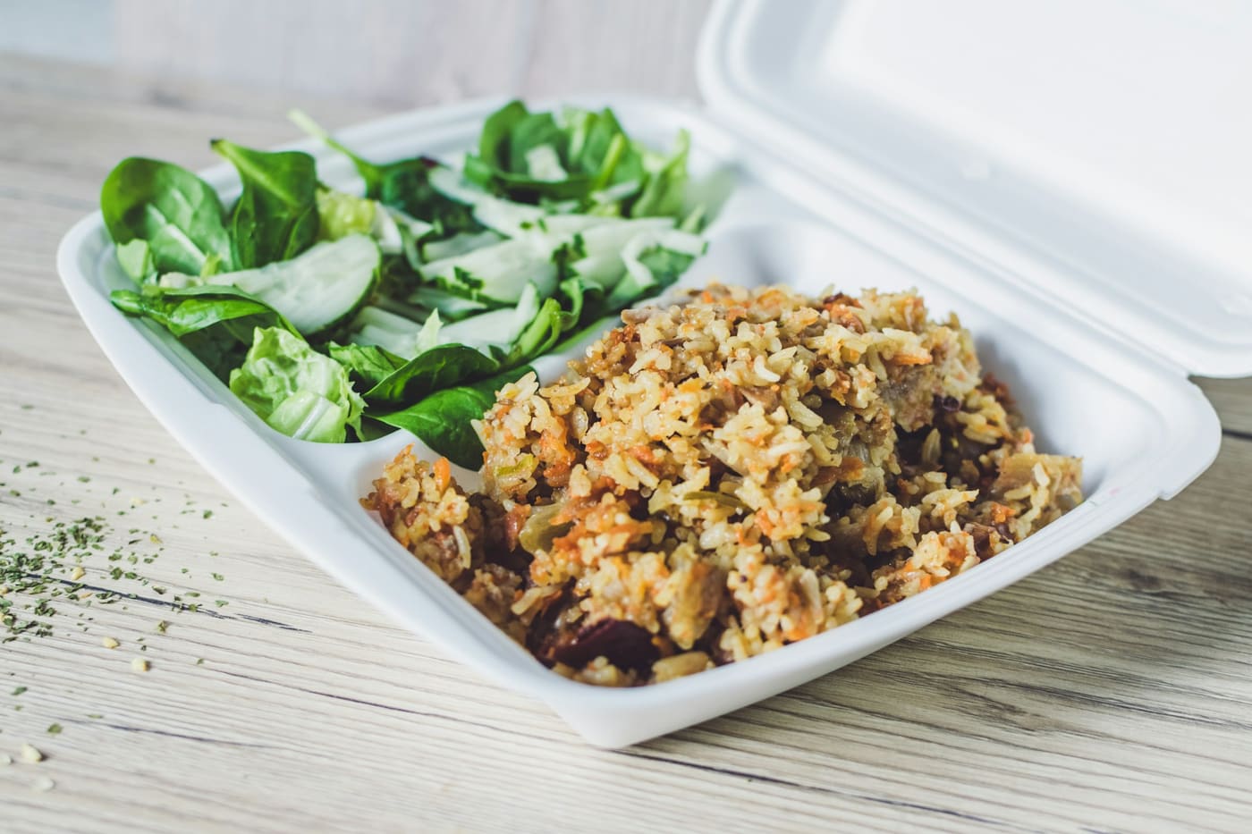 Spiced rice with a side salad, packed in a takeaway container